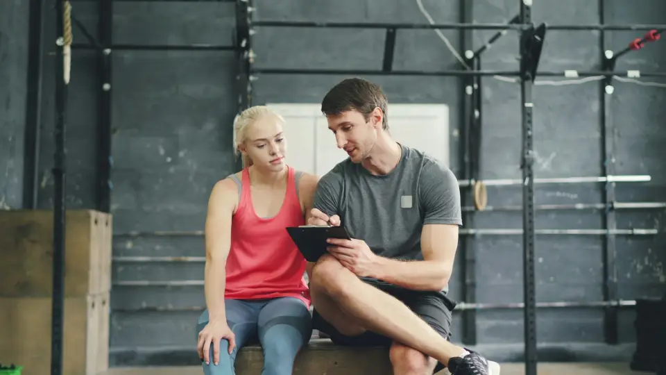 Trainer and client reviewing the workout on a tablet